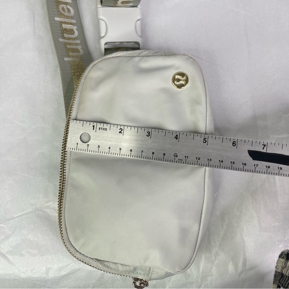lululemon bag with lululemon on strap Everywhere Wordmark Crossbody Belt 1L Leather Backpack - Traveller's Color:Black/Tan Synthetic Leather Once you find your #onthego